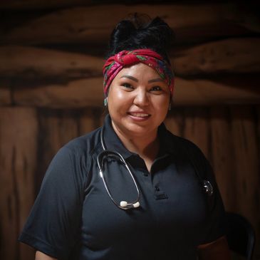 Smiling healthcare professional with a stethoscope and a colorful headband.