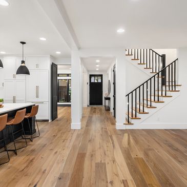 A large open floor plan with wood floors and white walls.