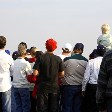 Personas mirando algo al frente al aire libre.