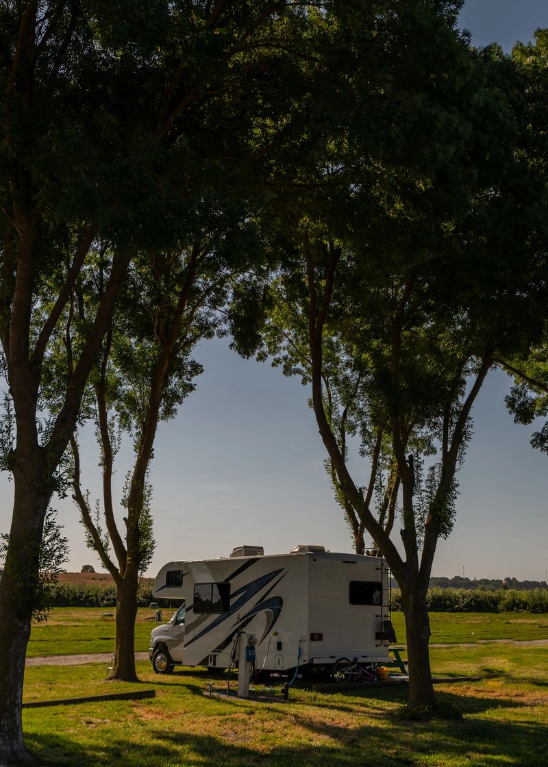 Rv camper trailer parked under trees in a quiet remote spot
