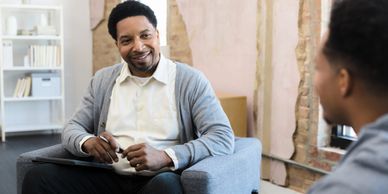 A man attentively listens during a counseling session in a cozy room.
