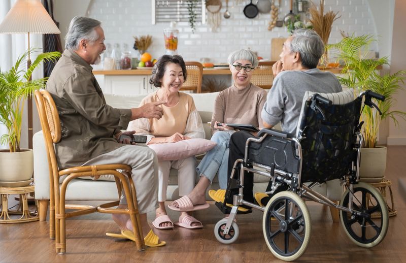 Group Asian seniors friends are sitting in the living room of a home together, enjoying talking together.