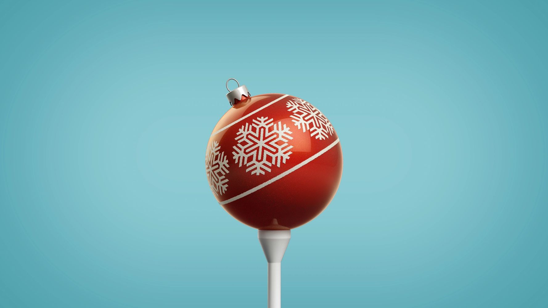 Red Christmas ornament with white snowflake patterns on a blue background.