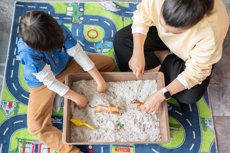 A Professional Child Psychologist Doing Sand Therapy With Little Boy