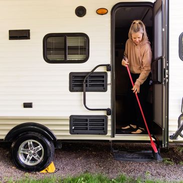 Woman sweeping steps of RV