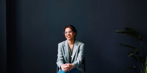 微笑着坐在椅子上的女性。