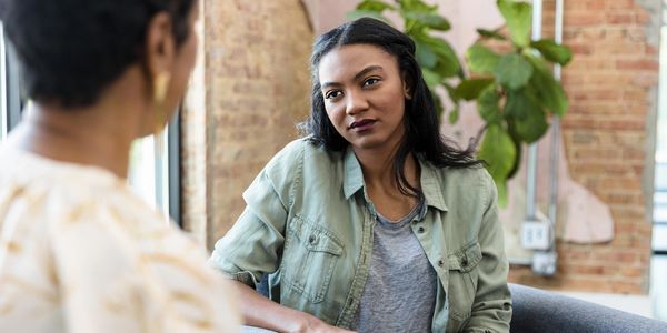 A woman attentively listens during a counseling session in a cozy room.