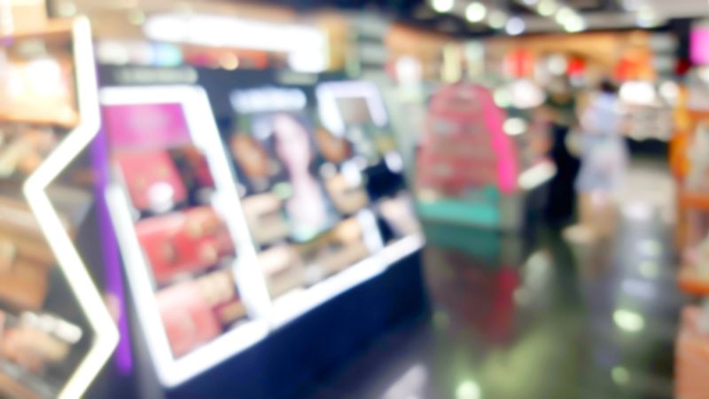 blurred view of modern beauty salon interior. different cosmetics products displayed on shelves. blurred image of cosmetic shop. Cosmetic shop background.