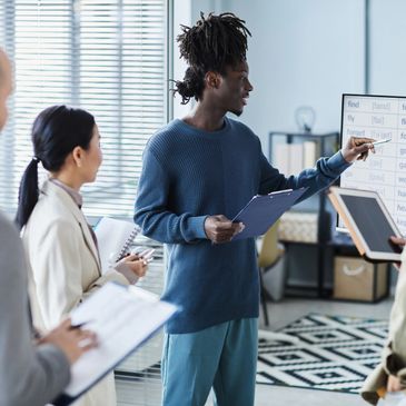 Young professional leading a team meeting with notes and charts.