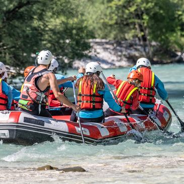 Group rafting on a river wearing safety gear.