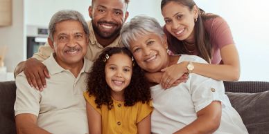Happy multi-generational family smiling together on the couch.
