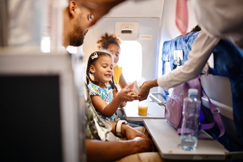 Cabin crew pushing service cart and serve to customer on the airplane during flight