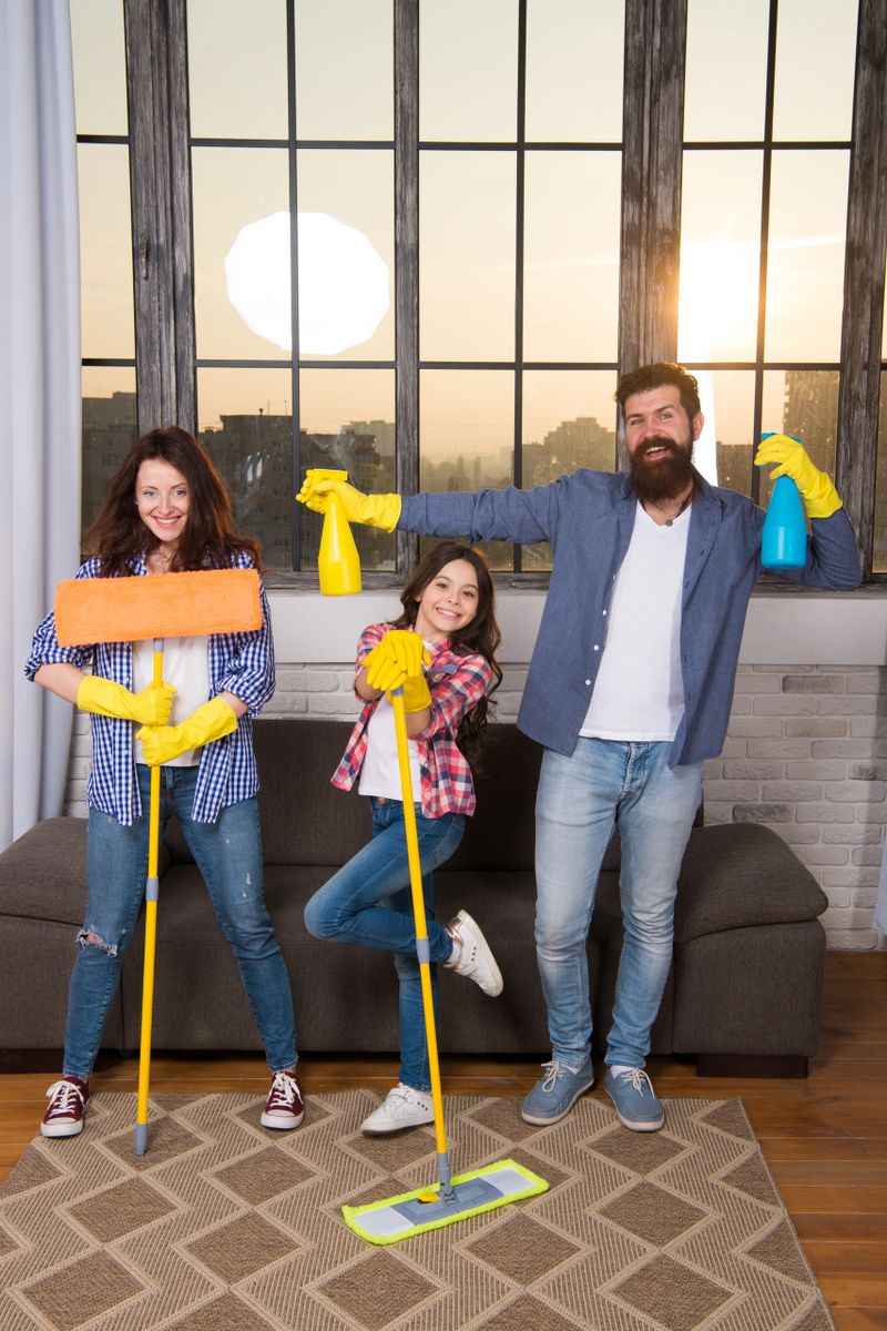 My home cleaned my way. Family clean house. Happy family hold cleaning products. Mother, father and daughter clean house. Family team housekeeping. Young family with cleaning equipment.
