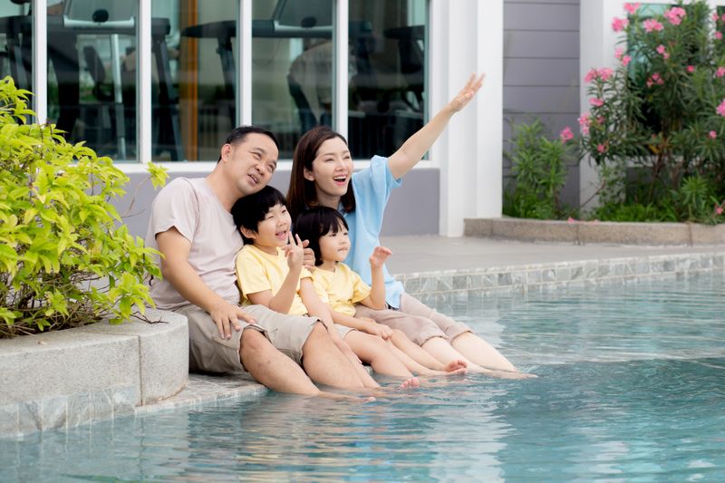 Happiness family relaxation at poolside in the home with enjoyment together, summer holiday, father and mother and children leisure at swimming pool with happy, relationship and bonding.