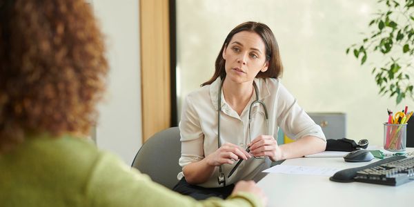 Doctor attentively listening to patient during consultation.