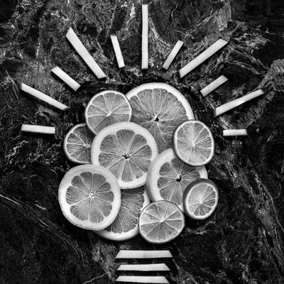 Lemon slices and cigarette butts arranged to form a light bulb shape.
