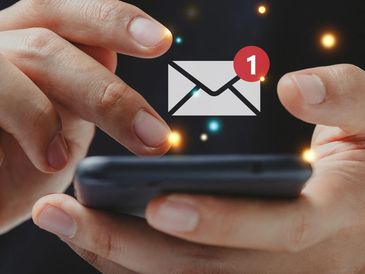 Hands holding a phone with a new message notification.