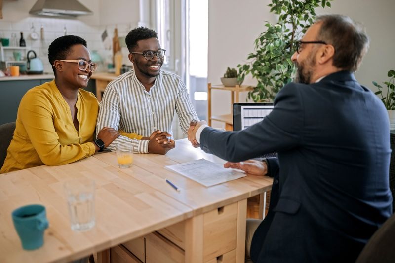 Shot of a handsome young man shaking hands with a financial advisor during a consultation at home