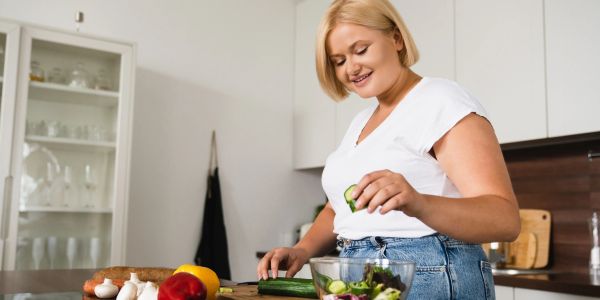 Woman preparing a salad in the kitchen.