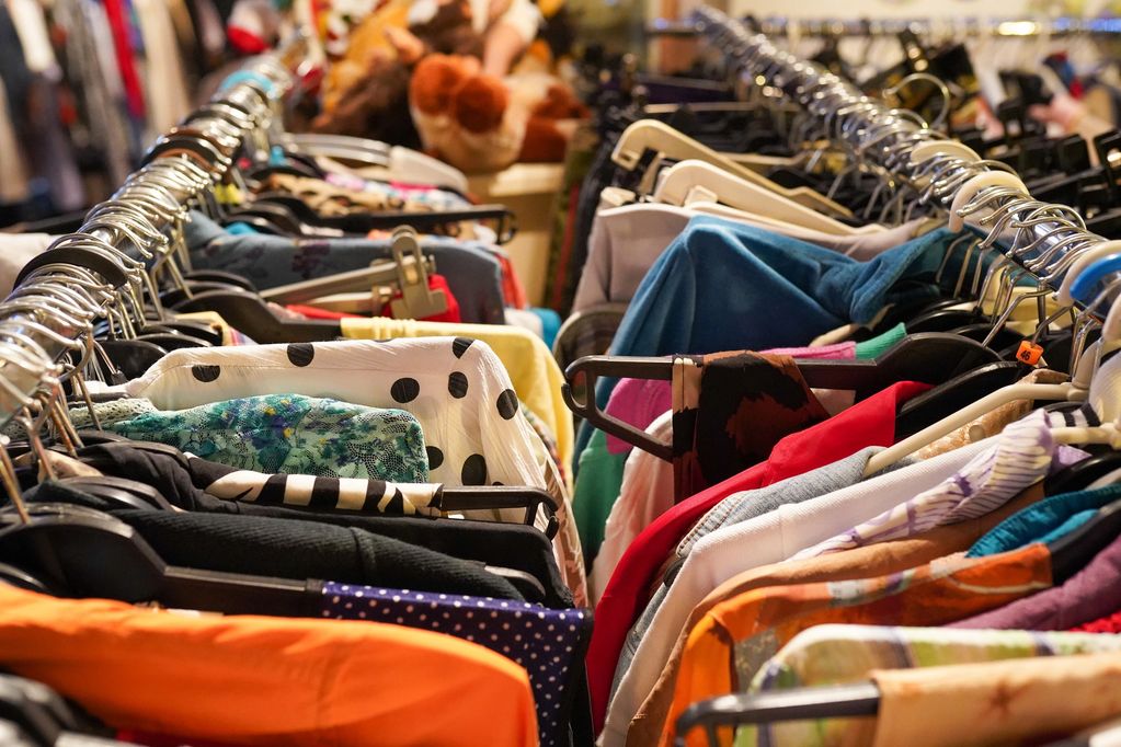 A rack full of colorful clothes on hangers.