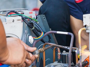 HVAC engineer servicing an outdoor air conditioning unit