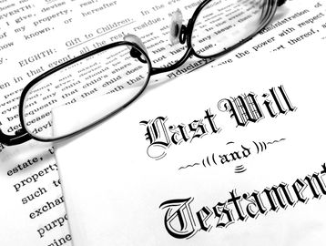 A pair of glasses rests on legal documents titled 'Last Will and Testament.'