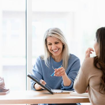 Two women having a friendly discussion indoors.