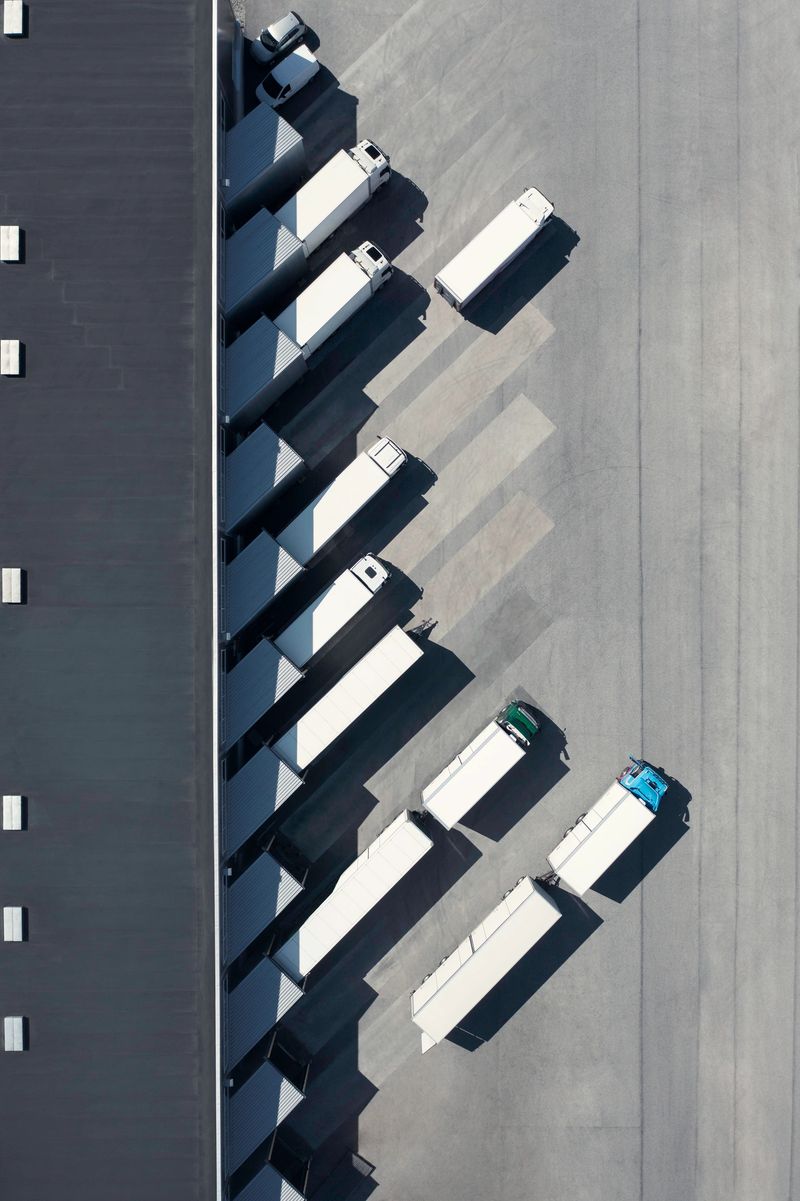 View from above of a distribution warehouse with loading docks and various trucks.