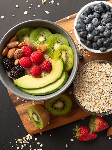 Healthy bowl with avocado, kiwi, berries, and almonds.