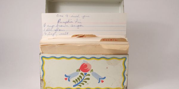 Vintage recipe box with handwritten recipe cards, featuring a pumpkin pie recipe.