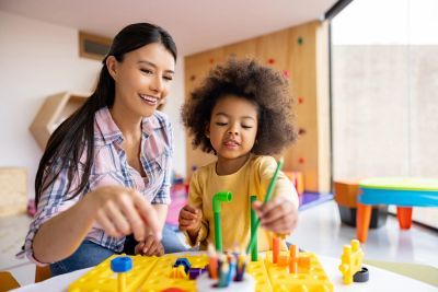 Woman and child playing with a construction toy.