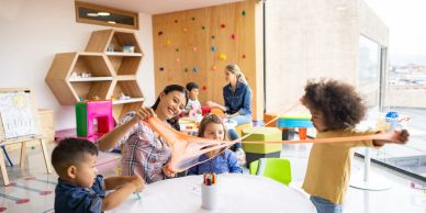 Children and teachers play with slime in a classroom.