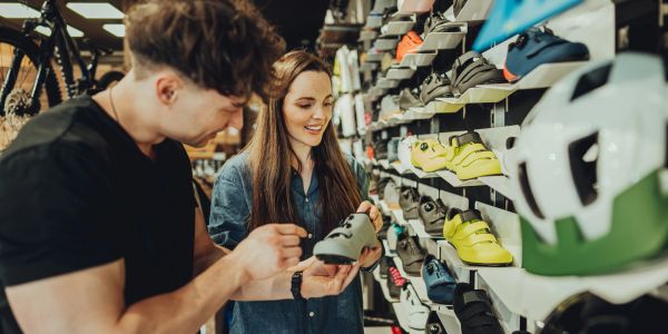 Young couple shopping for cycling shoes in a store.