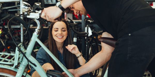 Happy woman getting a bike tuned up.