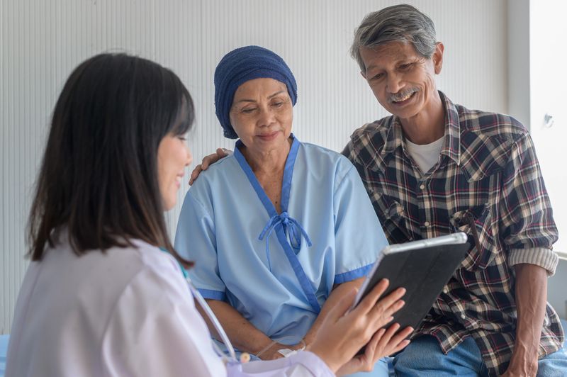 Cancer patient woman wearing head scarf after chemotherapy consulting and visiting doctor in hospital..