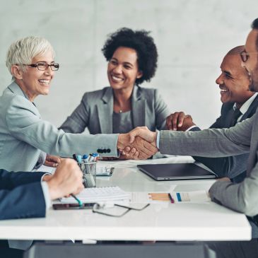 Business professionals shaking hands in a meeting room.