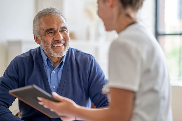 Senior man smiling while consulting with a healthcare professional.