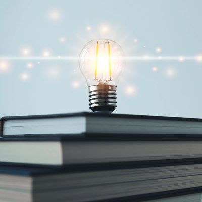 A lightbulb on a stack of books.