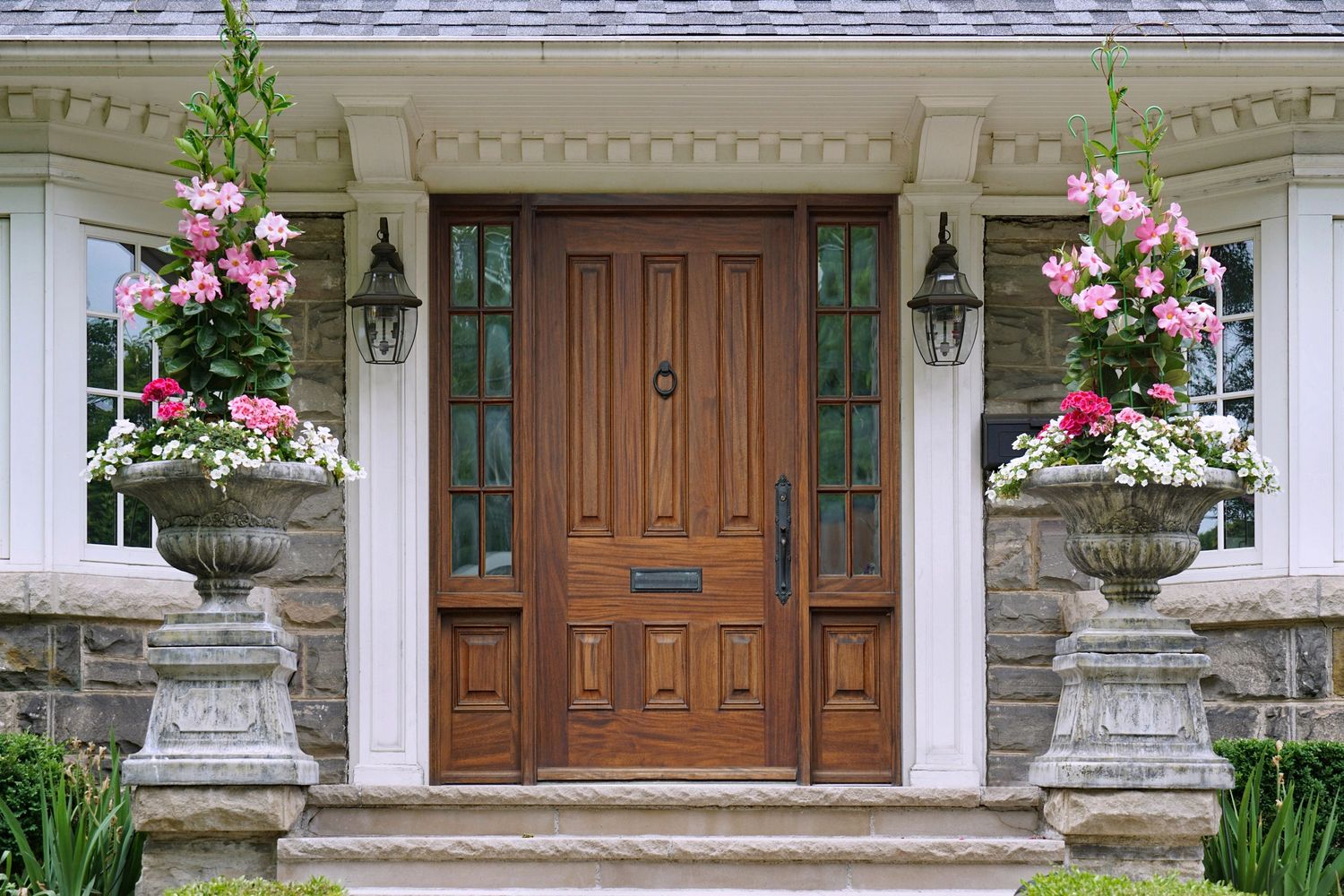 Classic wooden front door with symmetrical flower urns.