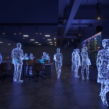 Holographic figures interact in a futuristic office space.
