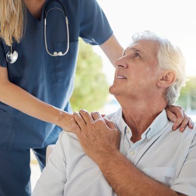 Nurse comforting elderly man.