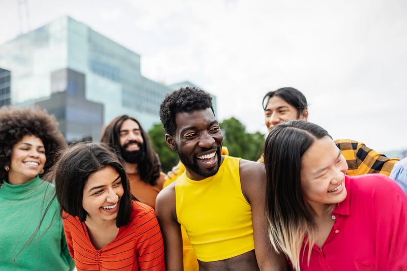 Young multiracial friends having fun together hanging out in the city - Friendship and diversity concept