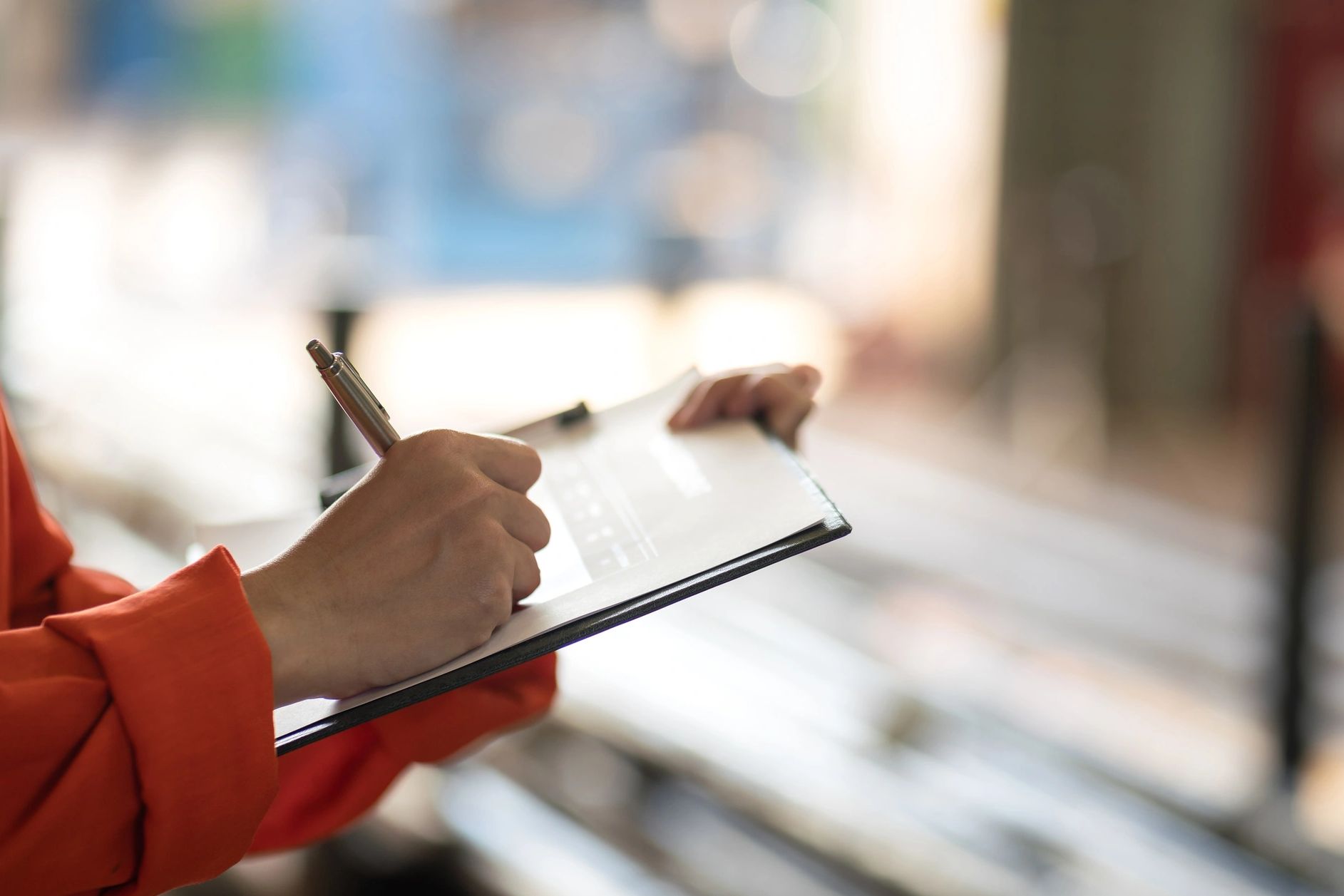 Person writing on a clipboard.