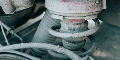 Close-up of a dusty car suspension spring.
