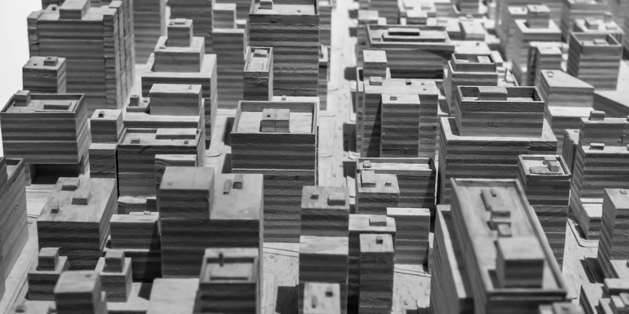 Black and white image of a detailed miniature city model with numerous buildings.