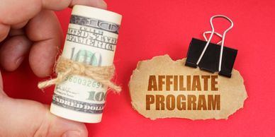 Rolled hundred-dollar bill and paper with 'Affiliate Program' text on red background.