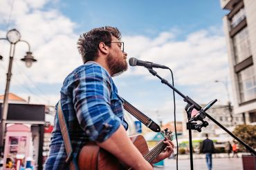 Musician passionately playing guitar on stage during a live performance.