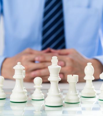 Chess pieces with a person in the background.