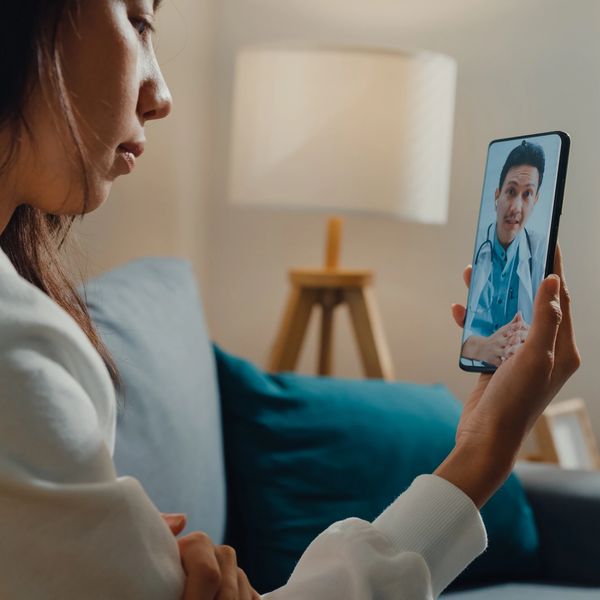 Woman having a video consultation with a doctor on her smartphone.