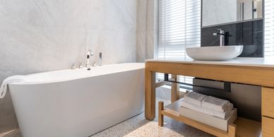 Modern bathroom with bathtub and wooden vanity.